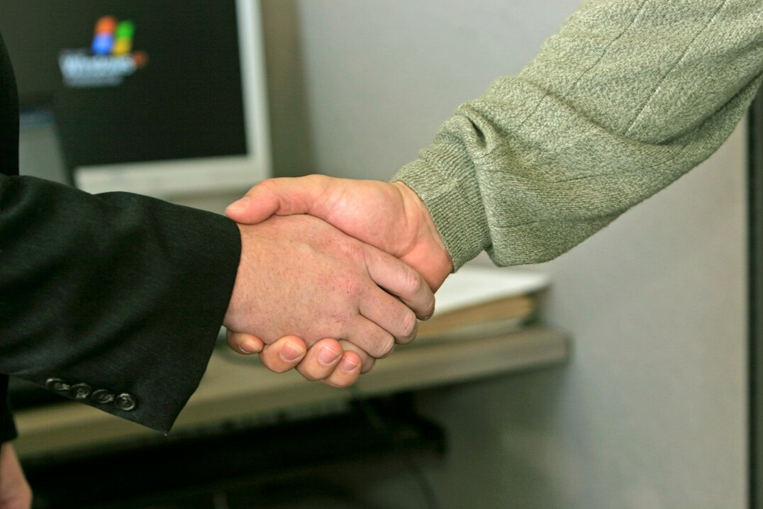 business handshake across table